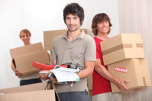 Removal team handling packed boxes and household items in West Ham