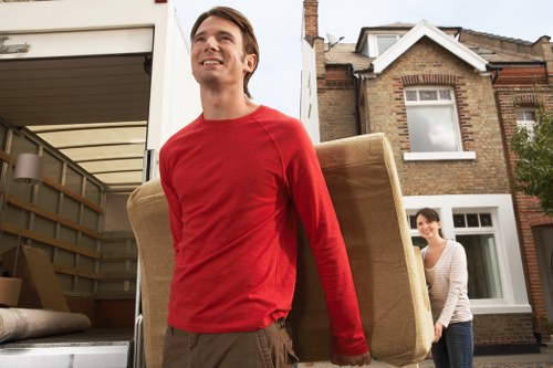 Local movers carrying furniture near West Ham transport and parking area